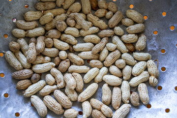 Close-up of a pile of fresh peanuts in a dustpan