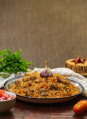 Delicious Fergana pilaf. Uzbek favorite dish on wooden background