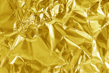 Gold foil leaf shiny texture, abstract yellow wrapping paper for background and design art work.