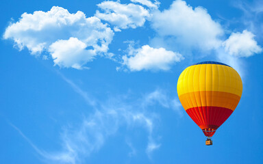 Beautiful hot air balloon flying against blue sky and white clouds