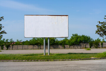 a large blank billboard on a city street parking lot	