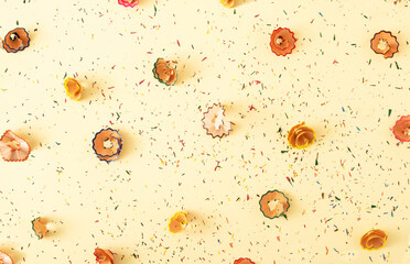 Colorful pencil shavings  on yellow pastel background. Back to school pattern. Minimalistic composition.