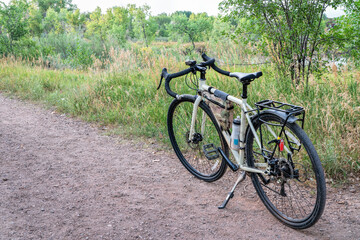 Fototapeta na wymiar touring bicycle on a gravel trail in one of Fort Collins natural areas along the Poudre River in northern Colorado, summer scenery at dusk
