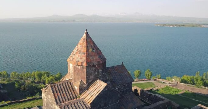 Aerial view of the most famous and popular monastery on Lake Sevan - Sevanavank. Video of the flight near the dome. Tourist attractions of Armenia