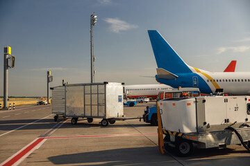 Airfield tractors near big modern airplane. Preparation of aircraft for boarding in airport hub on...
