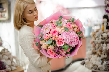 beautiful woman holds great bouquet of pink chrysanthemum hydrangea and roses