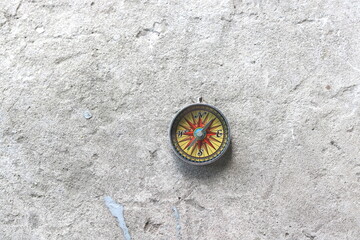 Fototapeta na wymiar round compass on gray concrete background as symbol of tourism with compass, travel with compass and outdoor activities with compass