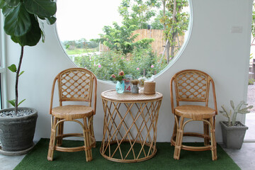 The wicker chairs and table on white concrete wall.