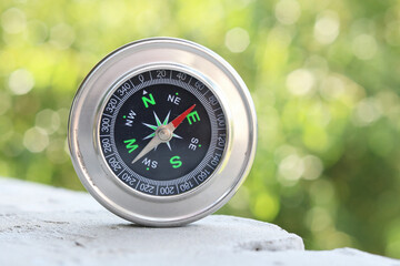 Classic navigation compass on natural background as symbol of tourism with compass, travel with...