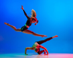 Stylish sportive caucasian couple, male and female dancer dancing contemporary dance on colorful...