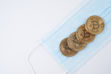 Concept of connection between fall and growth of cryptocurrency with coronavirus golden bitcoins isolated on white background close-up with copy space