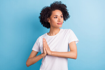 Portrait of attractive brunette dreamy girl praying hoping isolated over bright blue color...