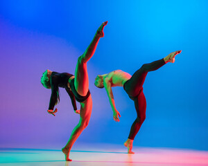 Stylish sportive caucasian couple, male and female dancer dancing contemporary dance on colorful...