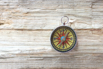 round compass on natural wooden background as symbol of tourism with compass, travel with compass and outdoor activities with compass