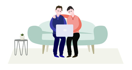 Two gay men are hugging on the couch and looking at a laptop. Cozy interior.