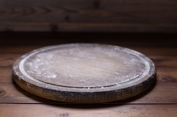 Pizza cutting board for homemade bread cooking or baking and flour on table. Wooden tabletop