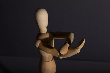 Wooden mannequin shows obscene gesture fuck off with hands on gray background. protest, riot,...