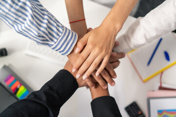 Hands of different nationalities, different skin colors, placed on top of each other, one on top of...