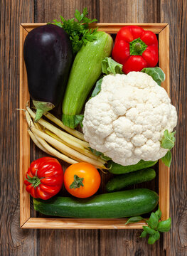 Close-up photo of fresh farm organic vegetables and greenery. Top view on wooden  background