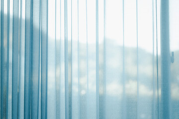 Airy transparent blue sheer curtain for see through and soft light on balcony window and close in...