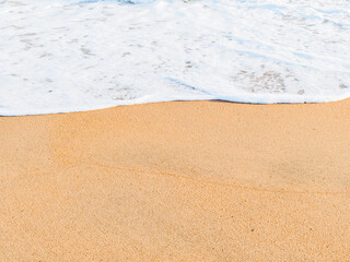 the wave covers the sandy shore, copy space