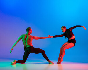 Stylish sportive caucasian couple, male and female dancer dancing contemporary dance on colorful...