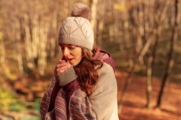 Woman heating her hands while spending autumn day outdoors