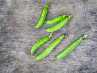 Pods of young green peas on a street table