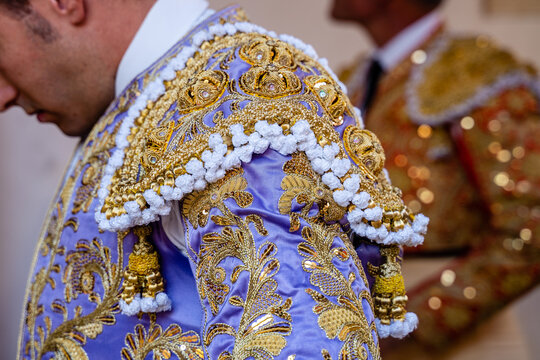 Crop bullfighter in pink traditional costume