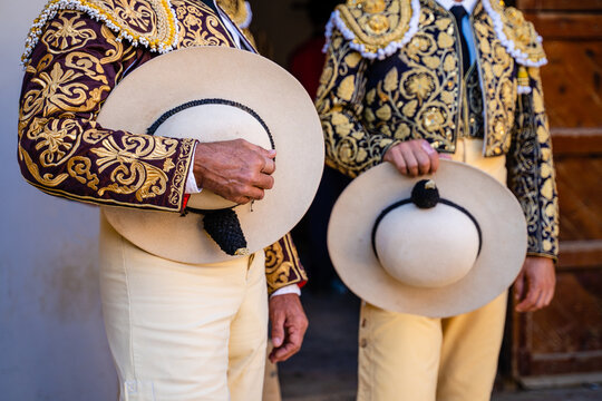 Crop bullfighters in golden traditional costume and hats