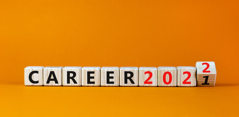 Planning 2022 career new year symbol. Turned a wooden cube and changed words 'career 2021' to 'career 2022'. Beautiful orange background, copy space. Business, 2022 career new year concept.