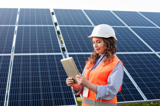 Female engineer is working with tablet at solar station