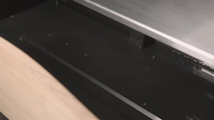 Empty open drawer and shiny metal shelf in contemporary large refrigerator in illuminated premise extreme close view