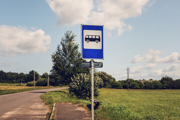 Bus stop blue and white sign on metal pole on suburban area
