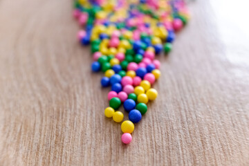 Pointed triangle composed of small colored balls, focus on the front and the background out of focus.