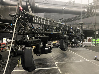 Moving head spotlight devices are clamped on a steel rigging truss. Installation of stage lighting...