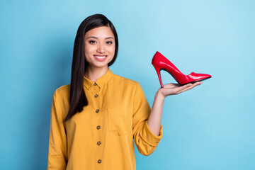 Photo of young asian girl happy positive smile show stilettos promo offer advice sale isolated over...