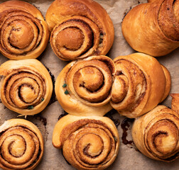 Freshly baked cinnamon buns on an organic background top view. patern. copy space