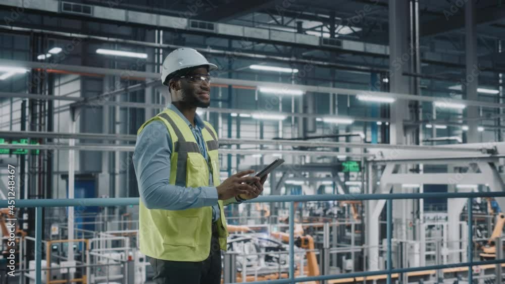 Poster happy african american car factory engineer in high visibility vest using tablet computer. automotiv