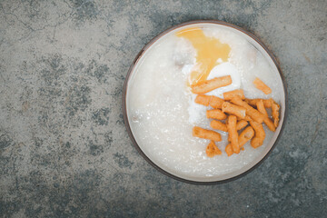 Thai rice porridge with mini deep-fried dough stick and egg yolk