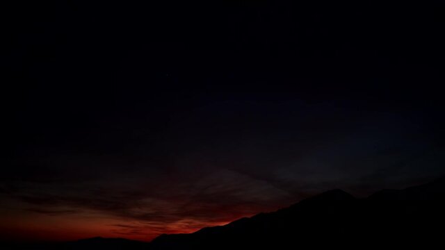 Sunset over hilly land, night is falling. Nature landscape. Time lapse