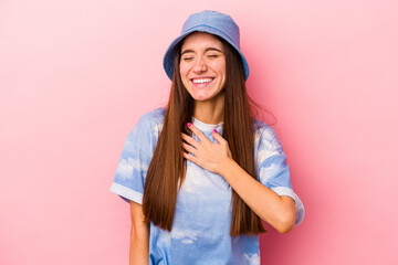 Naklejka premium Young caucasian woman isolated on pink background laughs out loudly keeping hand on chest.