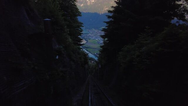 Red Funicular Train driving downhill from Harder Kulm, Top of Interlaken. Funicular drives tourists up and down from popular view point. Transportation, tourism - Swiss Alps, Interlaken, Switzerland