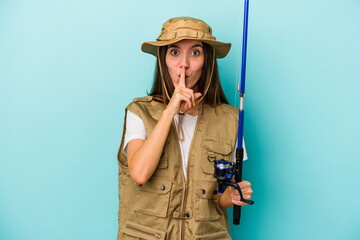 Young caucasian fisherwoman isolated on blue background keeping a secret or asking for silence.