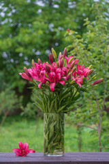 Beautiful bouquet of red lily flowers in a vase in the garden, Ukraine, close up