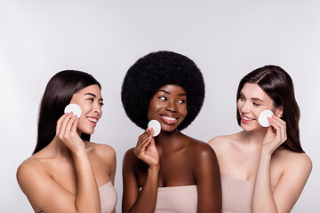 Photo of three young attractive woman happy positive smile swab toner skincare sponge isolated over grey color background © Beauty Hero