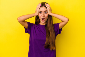 Young caucasian woman isolated on yellow background being shocked, she has remembered important meeting.