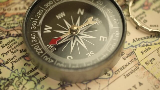 Old compass on travel antique map background close-up, navigation and destination footage