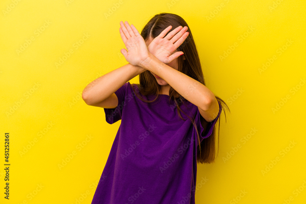 Wall mural young caucasian woman isolated on yellow background keeping two arms crossed, denial concept.