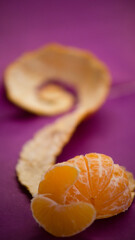 fresh and juicy orange on a purple background, orange peel, fruit composition, orange slices